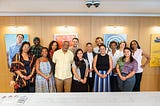 A group photo of 15 diverse Firelight Media staff members posing for the camera.