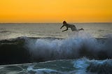 Woman flying off surfboard in the sea