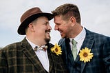 Two grooms looking at one another and smiling