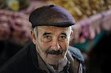 Adorable old man in a flat-cap hat, with beautiful eyes that stare into your soul.