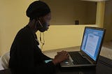 A Black lady peering into her personal computer