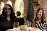 Photo of Monica and Priscilla, co-directors, sitting at a table at a restaurant.