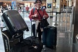 My 18 year old daughter at the airport with all of her suitcases checking them to fly to college.
