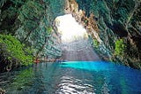 Beautiful cave with light coming through to shine on blue water