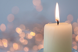 Image of a lit candle, representing the way that light can alter the mood of a piece of writing
