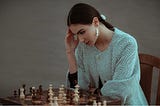A woman making a decision over a chess board