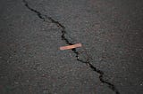 A crack in the road patched with a band-aid.