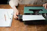 Writer adjusting a typewriter