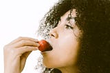 woman tasting a strawberry