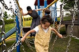 Mom playfully engaging with her daughter at a playground