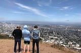 Three young men look over a city skyline