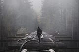 A person walking on broken railroad tracks. Why bother making choices and decisions to live your life?