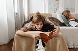 Teenager reading on a sofa