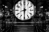 a black and white clock a the top of a staircase that reads 8:30pm