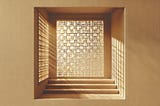 The author created this sepia-colored, minimalistic, abstract image of a latticed window with sunlight seeping through using ChatGPT.