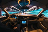 time lapse photo of a man driving a car taken from the interior, with visible lines of light outside the vehicle