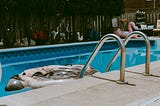 Home swimming pool with large floaties and bird statues.