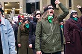 A group of white women protesting with a blindfold on