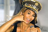 Beyonce from her “Love on Top” music video gesturing a phone with her hand