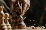 Man’s hand holding a horsehead chess piece