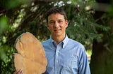 John Sakulich hold one of his tree stumps in his right hand