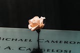 A single rose on a memorial with the names of those who died in 9/11