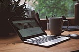 laptop on desk with coffee mug