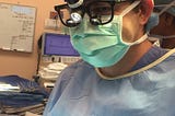Surgeon in mask, hat, gown