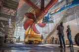 Workers observe a propeller installation for USS Nimitz at Puget Sound Naval Shipyard and Intermediate Maintenance Facility in Bremerton, Washington, October 16, 2018. Photo by Brian Kilpatrick/U.S. Navy