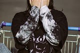 Image of a girl covering her face while posing for the photoshoot of the streetwear brand