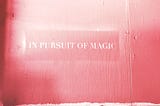 A pink screen with the quotation “In Pursuit of Magic”
