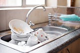 Kitchen sink full of dirty dishes