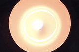 Overhead photo taken of a round white lit candle.