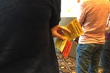 A person from behind holding several Post-it notes between his fingers while attending the NCredible Framework Workshop.