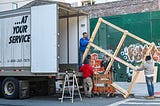 People putting a frame on a truck.