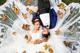 An image of a bride and groom lying on the ground for photoshoot.