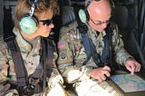 Two Army soldiers (including the author) in a helicopter reviewing maps as they fly over flooded parts of South Carolina following Hurricane Florence in 2018.