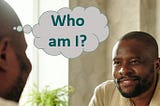 Black man in bathrobe looking into mirror and asking “who am I?”