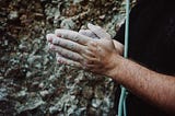 Rock climber’s hands cover with chalk.