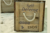 Picture of a Wooden Crate with the words “Self Defense Odds and Ends” on it.