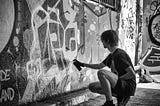 Teen making street art on a wall