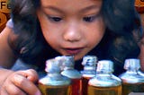 Child looks at olive oil bottles