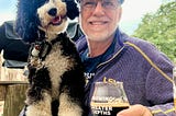 Photo of Jeff and his puppy Baisie at a brewery. Photo by Time2Geaux Visual, used by permission.