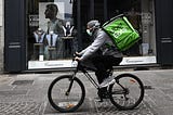 An UberEats delivery-person on a bike.