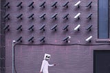 man walking wearing white with a mask under an installation of surveillance cameras