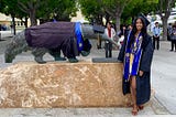 A picture of me, Ami, in my graduation attire in front of an Anteater statue.