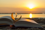 a book of poetry on a beach and a lovely sunset
