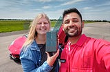 Sophie and Mrwhosetheboss on an airfield with a Lamborghini behind.