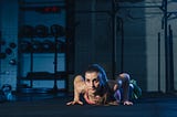 Fit woman in colourful sportswear doing burpees on a exercise mat in a grungy industrial type space