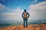 https://www.pexels.com/photo/man-in-blue-dress-shirt-and-blue-jeans-and-orange-backpack-standing-on-mountain-cliff-looking-at-town-under-blue-sky-and-white-clouds-732629/
